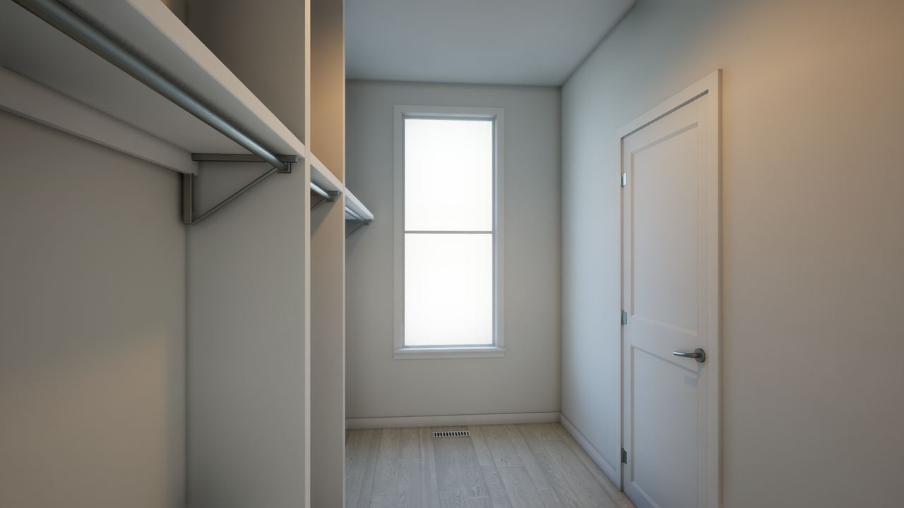Walk-in closet with hanging rails on both sides and a narrow window on the far wall.