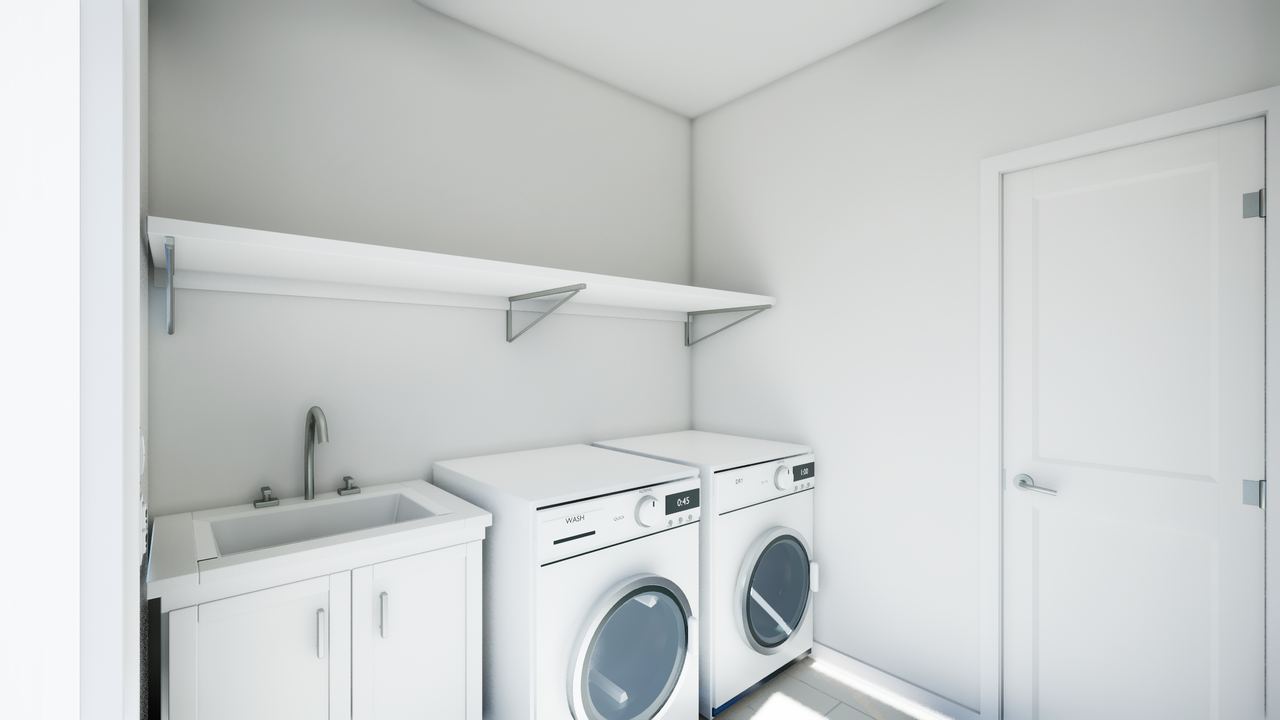 Laundry with front-loading washer and dryer, white wall cabinets and a utility sink.